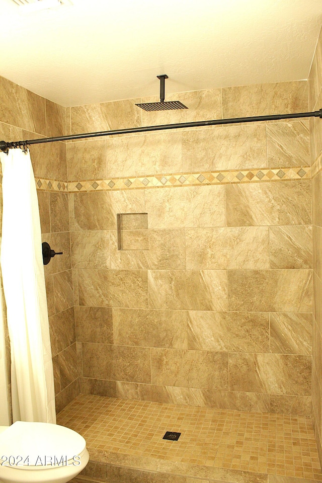 bathroom featuring a shower with curtain and toilet