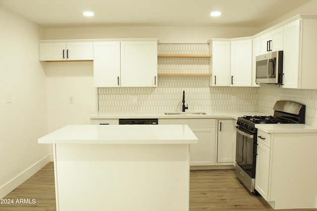 kitchen with white cabinets, a kitchen island, sink, and stainless steel appliances