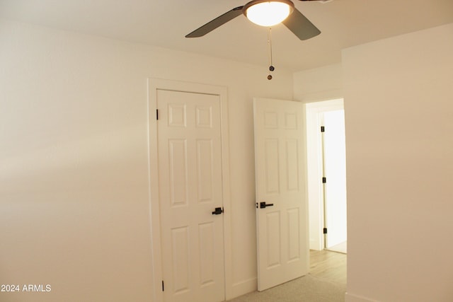 interior space featuring ceiling fan and light colored carpet