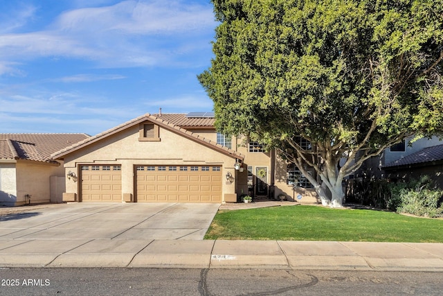 view of front of house with a garage, a front yard, and solar panels