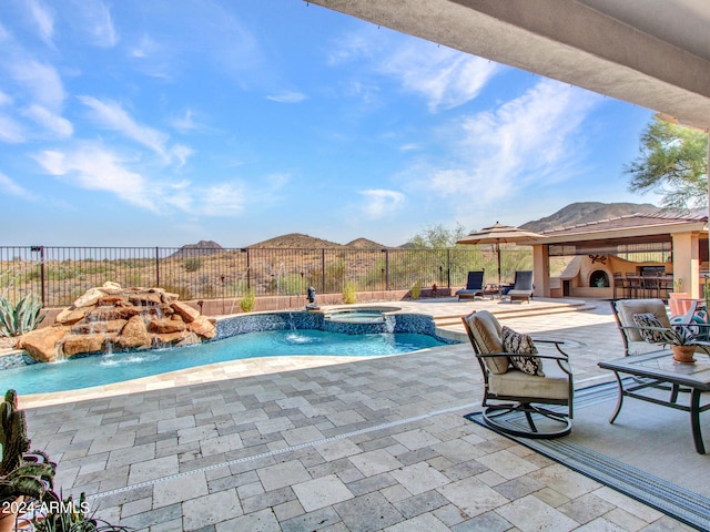 view of swimming pool with pool water feature, an in ground hot tub, and a patio area