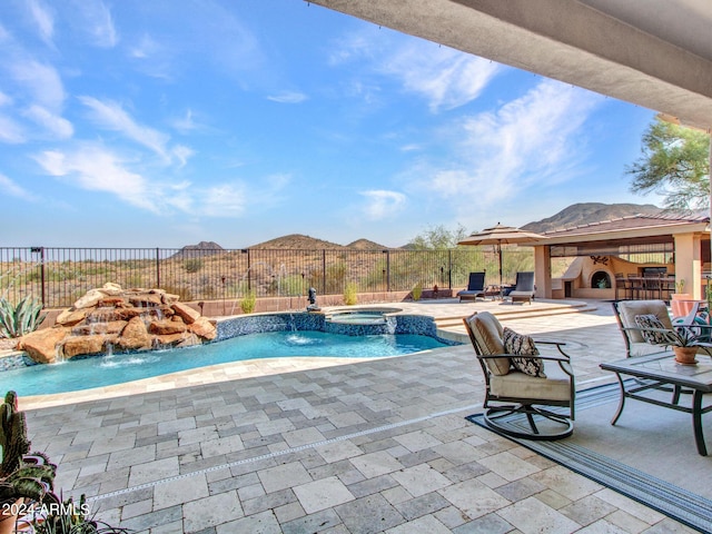 3220 W Feather Sound Dr, Anthem, AZ 85086 - view of swimming pool featuring a fireplace, a pool with connected hot tub, a fenced backyard, and a patio area