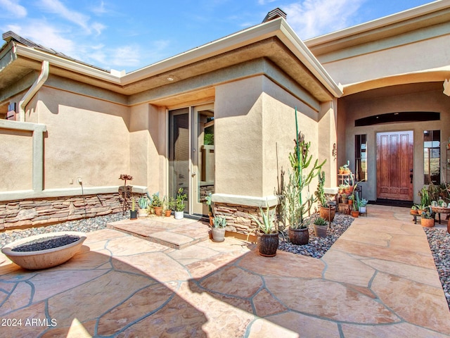 3220 W Feather Sound Dr, Anthem, AZ 85086 - doorway to property featuring a patio, a chimney, stucco siding, and stone siding