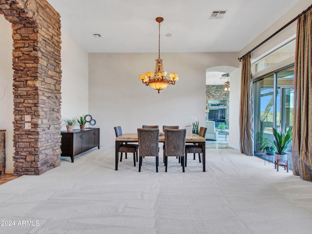 carpeted dining space featuring a notable chandelier