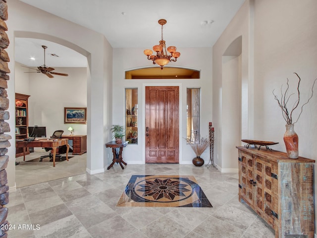 entrance foyer with ceiling fan with notable chandelier