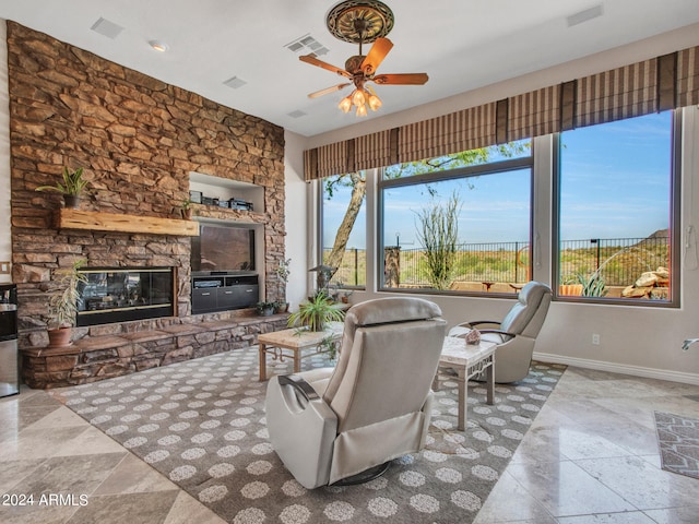 living room with ceiling fan and a fireplace