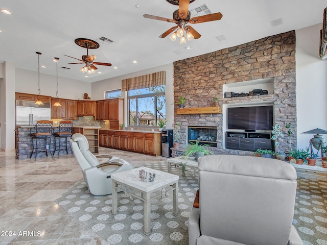 living room featuring a stone fireplace and ceiling fan