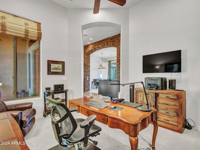 office space featuring ceiling fan with notable chandelier and light carpet