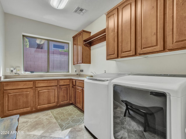 washroom with cabinets and washing machine and dryer