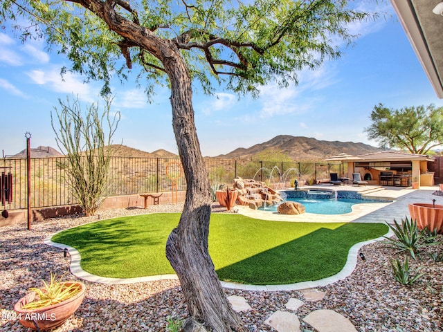 view of yard with pool water feature, a mountain view, a swimming pool with hot tub, and a patio area