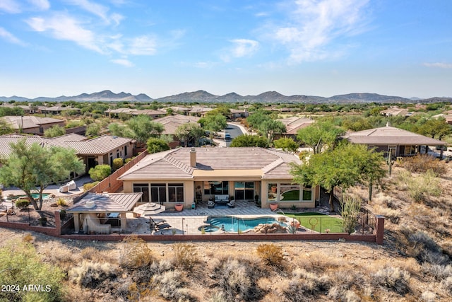 rear view of house with a mountain view and a patio