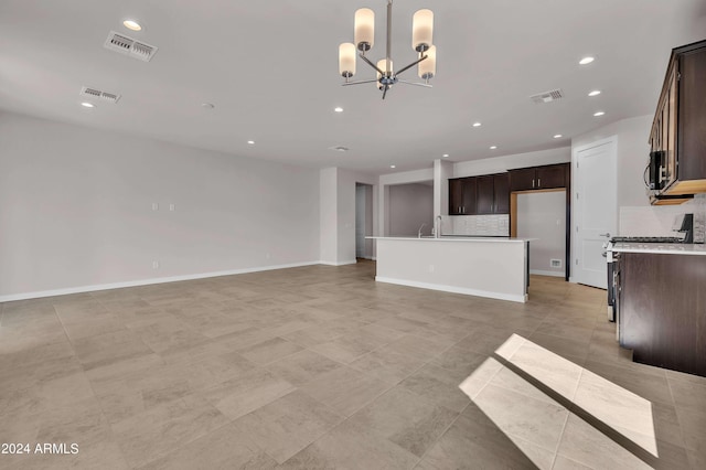 unfurnished living room with sink and a notable chandelier