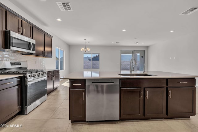 kitchen with sink, hanging light fixtures, stainless steel appliances, dark brown cabinetry, and tasteful backsplash