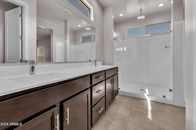 bathroom featuring tile patterned flooring, vanity, and walk in shower