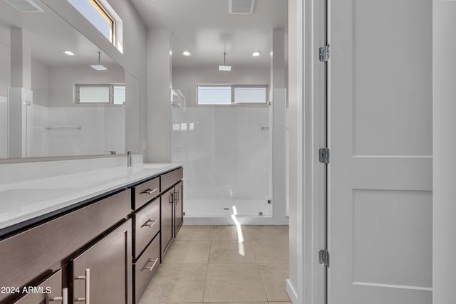 bathroom with tile patterned flooring, vanity, and walk in shower