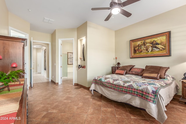 tiled bedroom with ceiling fan and ensuite bath