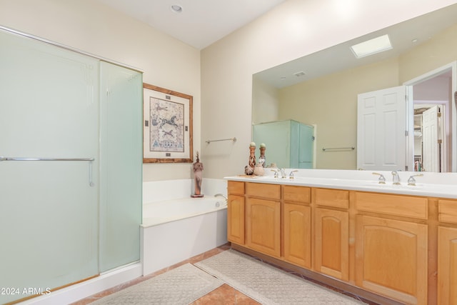 bathroom with vanity, a skylight, separate shower and tub, and tile patterned flooring