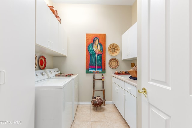 laundry area with washer and clothes dryer, light tile patterned floors, and cabinets