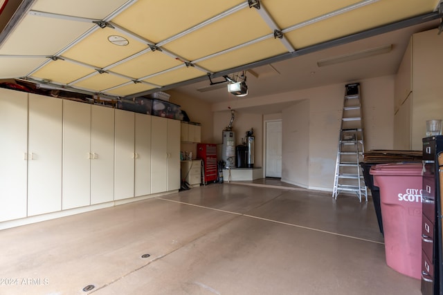 garage with gas water heater, a garage door opener, and water heater