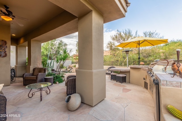 view of patio with grilling area, an outdoor kitchen, and ceiling fan