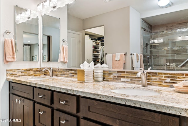 bathroom featuring vanity, an enclosed shower, and decorative backsplash