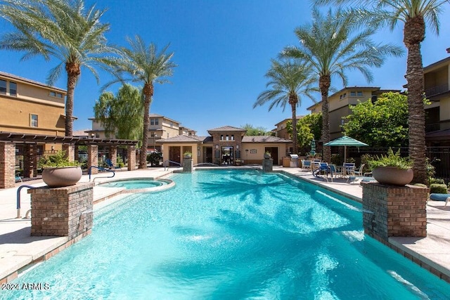 view of swimming pool featuring a community hot tub, a patio area, and pool water feature