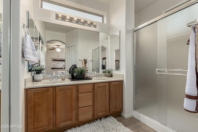 full bathroom featuring a sink, double vanity, and a shower stall