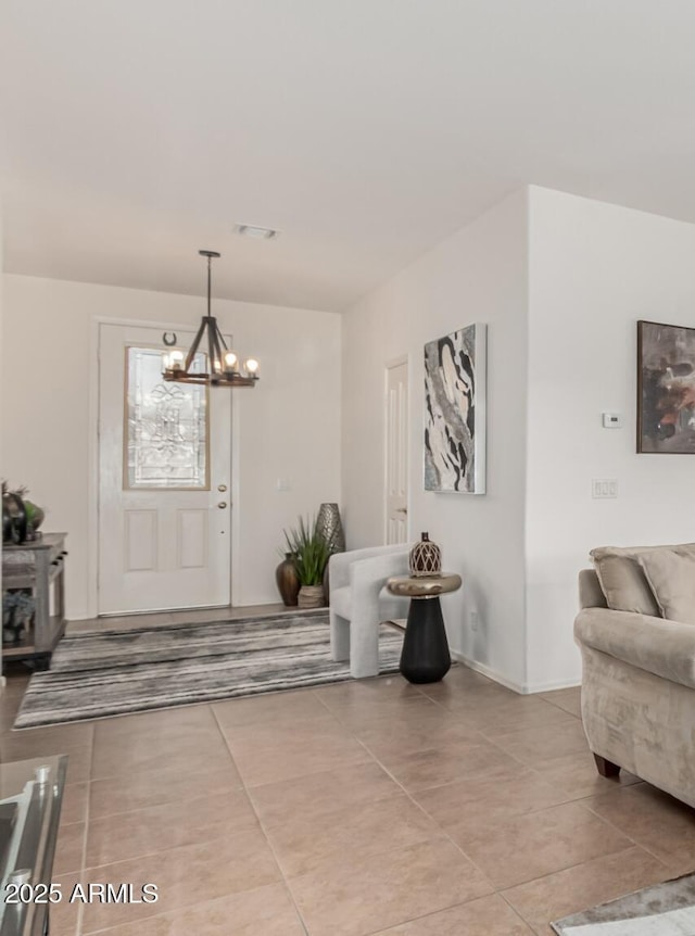 tiled entrance foyer featuring visible vents and a notable chandelier