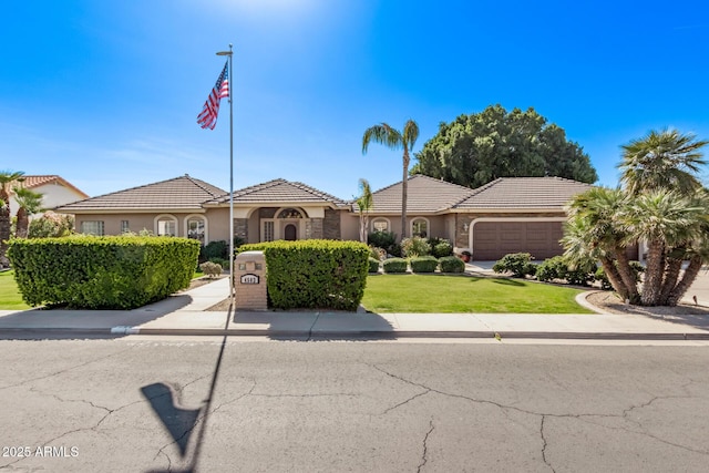 view of front of house featuring a garage and a front lawn