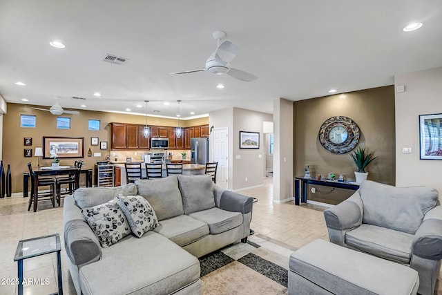 living room featuring light tile patterned floors and ceiling fan