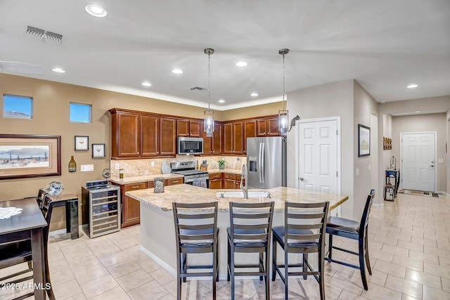 kitchen featuring sink, hanging light fixtures, stainless steel appliances, wine cooler, and light stone counters