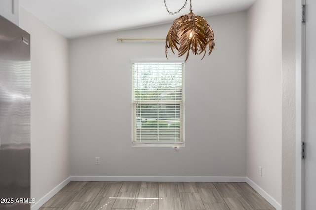 unfurnished room with baseboards and vaulted ceiling