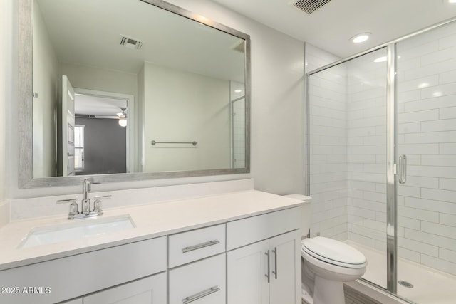 bathroom with toilet, a shower stall, and visible vents