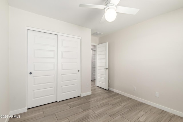 unfurnished bedroom featuring wood finish floors, a closet, and baseboards