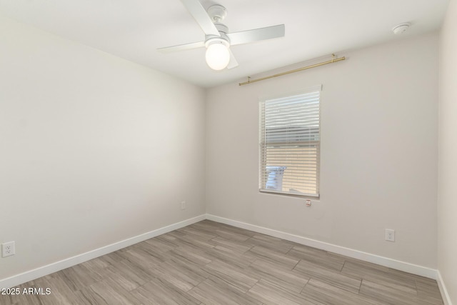 empty room with light wood-style flooring, a ceiling fan, and baseboards