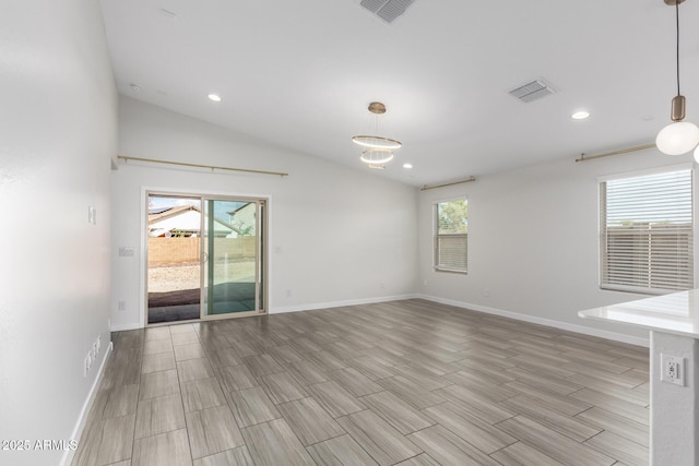 unfurnished room with lofted ceiling, baseboards, and visible vents