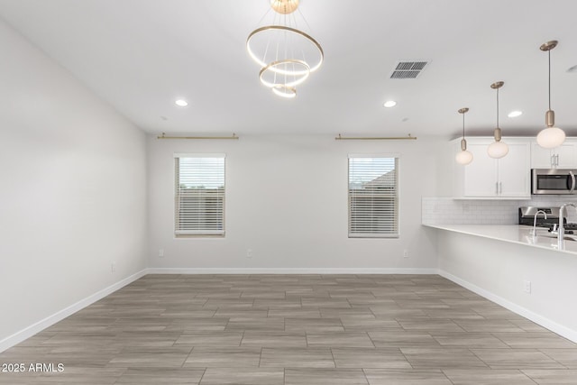 interior space with light countertops, appliances with stainless steel finishes, backsplash, and a wealth of natural light