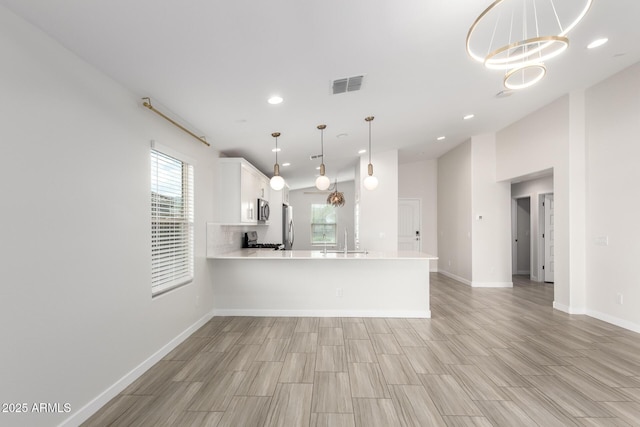 kitchen featuring light countertops, visible vents, appliances with stainless steel finishes, white cabinets, and a sink