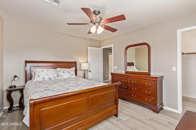 6847 S 27th Pl, Phoenix, AZ 85042 - bedroom featuring light wood finished floors, a ceiling fan, baseboards, and a walk in closet