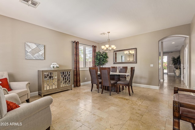 6847 S 27th Pl, Phoenix, AZ 85042 - dining area featuring arched walkways, stone tile flooring, baseboards, and healthy amount of natural light