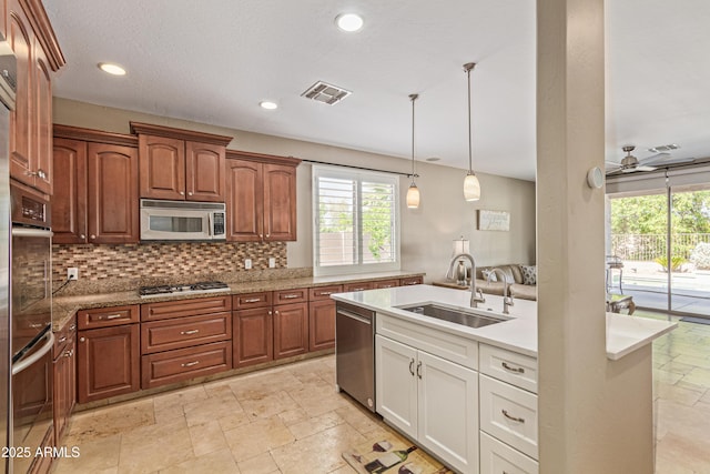 6847 S 27th Pl, Phoenix, AZ 85042 - kitchen with a sink, appliances with stainless steel finishes, stone tile flooring, decorative backsplash, and pendant lighting