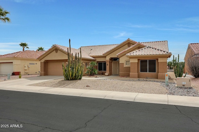 view of front of house with stucco siding, a garage, concrete driveway, and a tile roof