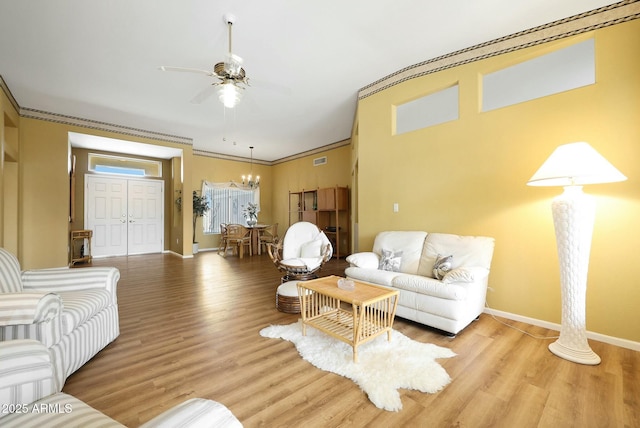 living room with baseboards, light wood finished floors, and ornamental molding