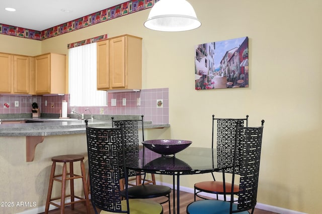 kitchen with tasteful backsplash, light brown cabinets, and baseboards