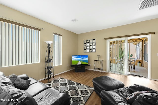 living area featuring wood finished floors, visible vents, and baseboards