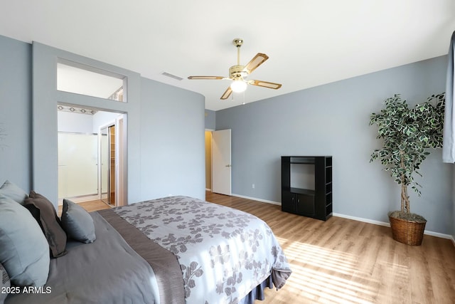 bedroom featuring visible vents, a ceiling fan, baseboards, and wood finished floors