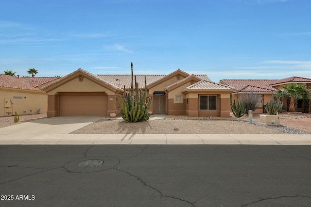 view of front facade with stucco siding, a garage, concrete driveway, and a tile roof