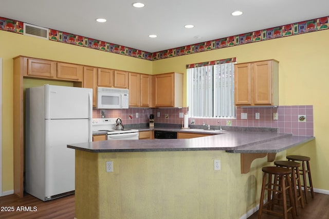 kitchen with white appliances, a peninsula, dark wood-type flooring, and backsplash