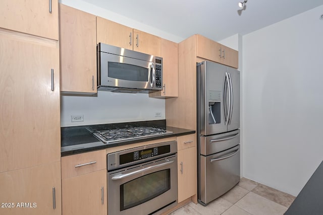 kitchen with light brown cabinets, light tile patterned floors, and stainless steel appliances