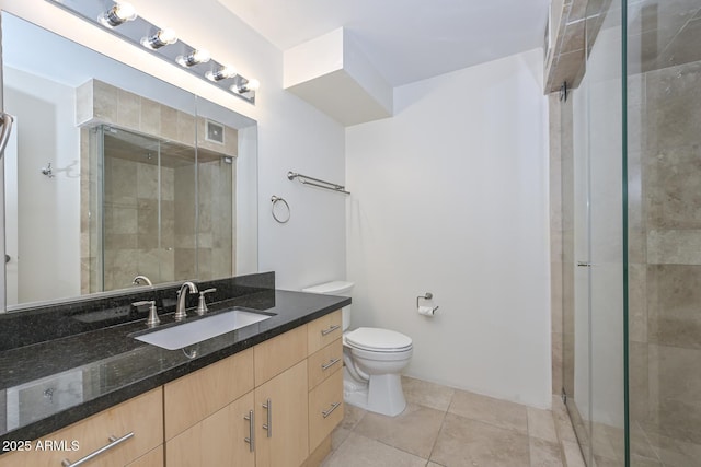 bathroom featuring an enclosed shower, vanity, tile patterned flooring, and toilet